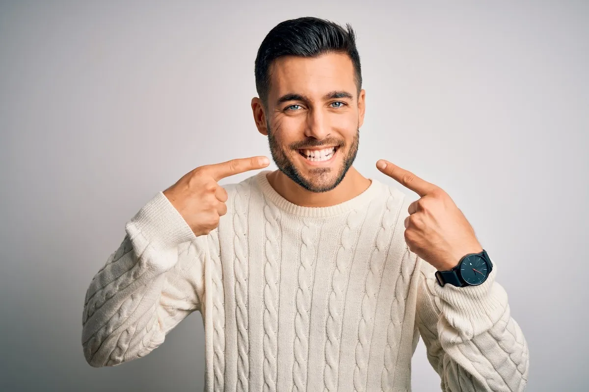 Man pointing to his healthy smile
