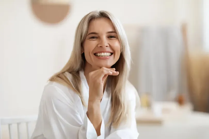 Woman smiling with her chin resting on her hand